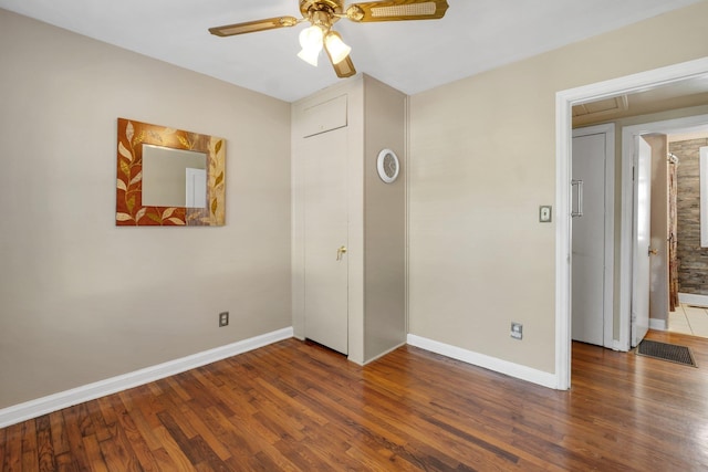 unfurnished bedroom featuring ceiling fan and dark hardwood / wood-style flooring