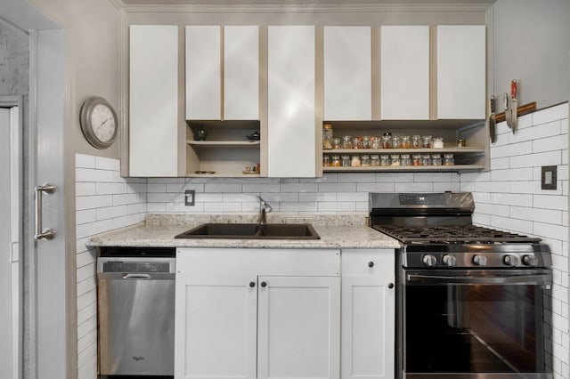 kitchen featuring tasteful backsplash, sink, white cabinetry, stainless steel appliances, and light stone counters