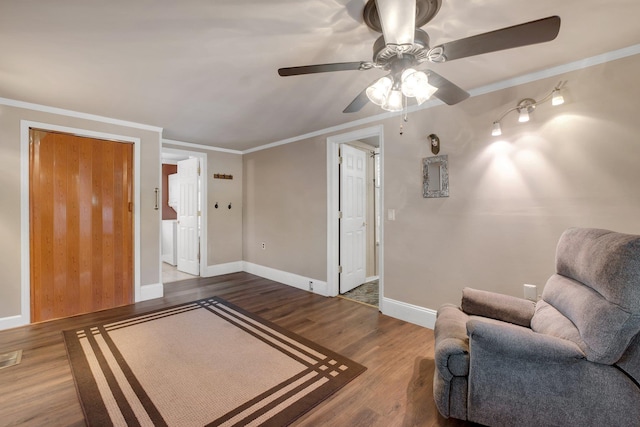 living area featuring hardwood / wood-style flooring, ornamental molding, and ceiling fan