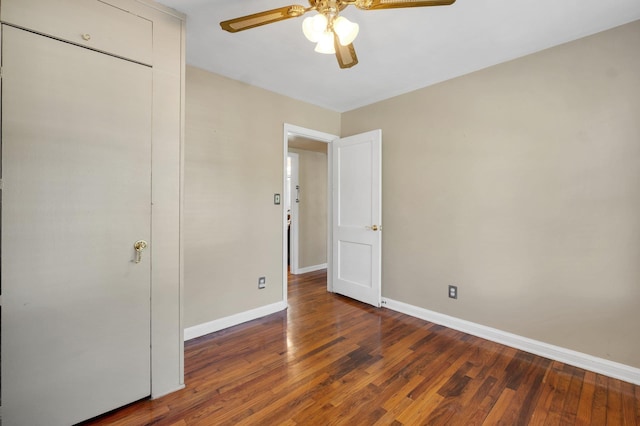 unfurnished bedroom with ceiling fan and dark hardwood / wood-style floors