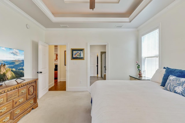 carpeted bedroom with ceiling fan, ornamental molding, and a raised ceiling