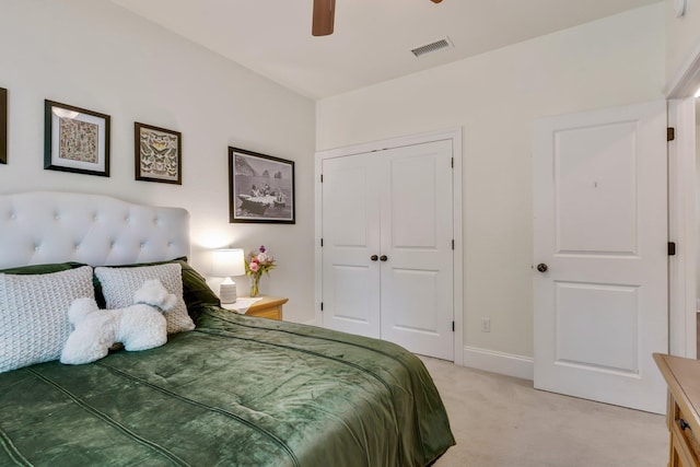 bedroom featuring ceiling fan, light colored carpet, and a closet