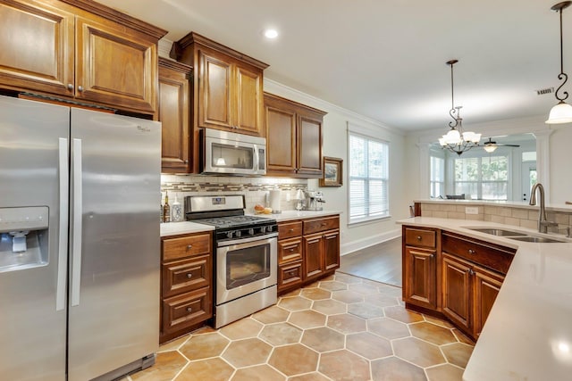 kitchen featuring hanging light fixtures, decorative backsplash, stainless steel appliances, and sink