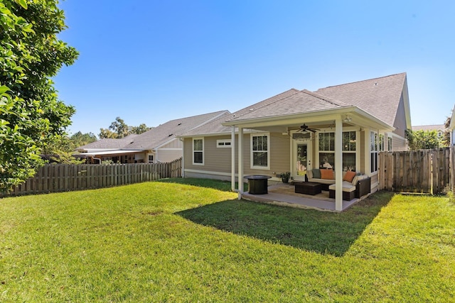 rear view of house featuring ceiling fan, an outdoor living space, a yard, and a patio area