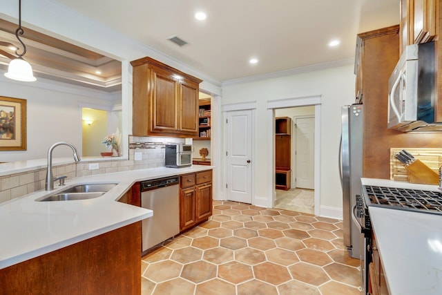 kitchen with pendant lighting, stainless steel appliances, crown molding, and sink