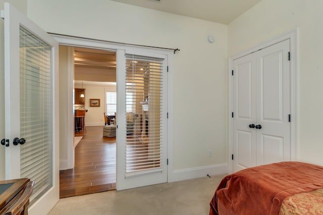 bedroom featuring a closet, light colored carpet, and french doors