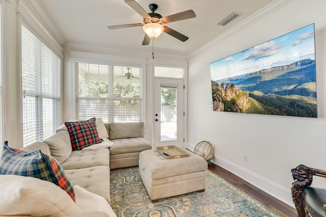 living room with a healthy amount of sunlight, ornamental molding, and dark hardwood / wood-style floors