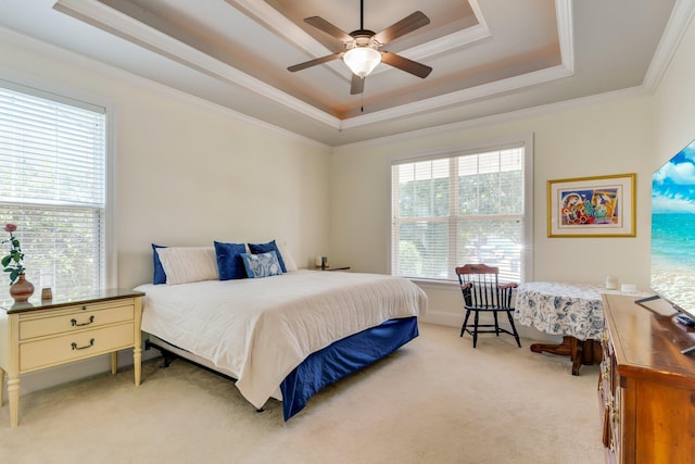 bedroom featuring crown molding, light colored carpet, a tray ceiling, and ceiling fan