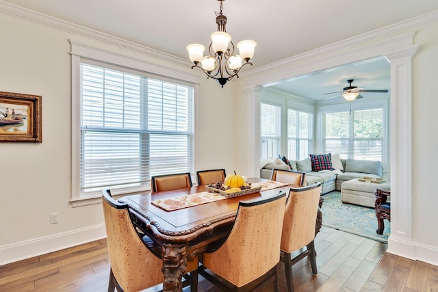 dining space featuring hardwood / wood-style floors, ceiling fan with notable chandelier, ornamental molding, and decorative columns