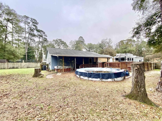 back of house with a covered pool and a lawn