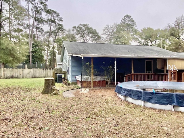 back of house featuring a swimming pool side deck and a lawn