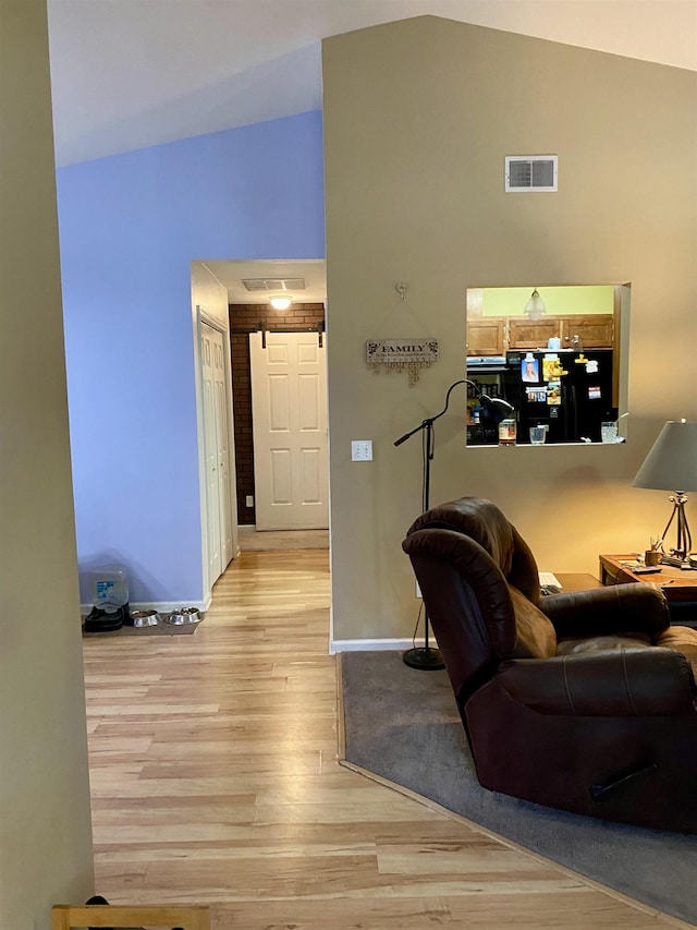 living room with light hardwood / wood-style flooring and high vaulted ceiling