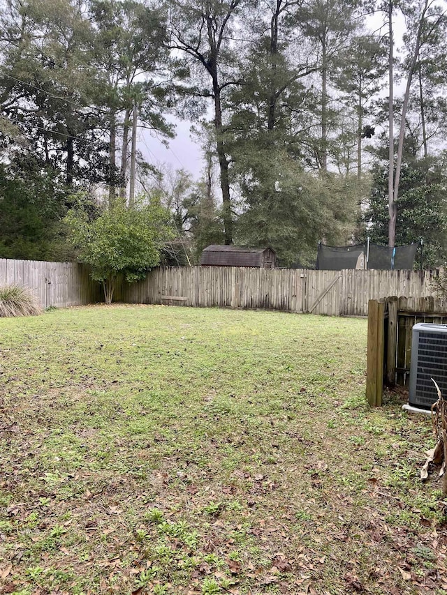 view of yard featuring a trampoline and central air condition unit