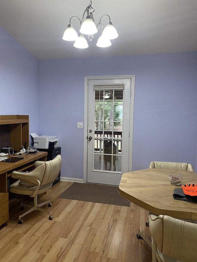 home office featuring light wood-type flooring and an inviting chandelier