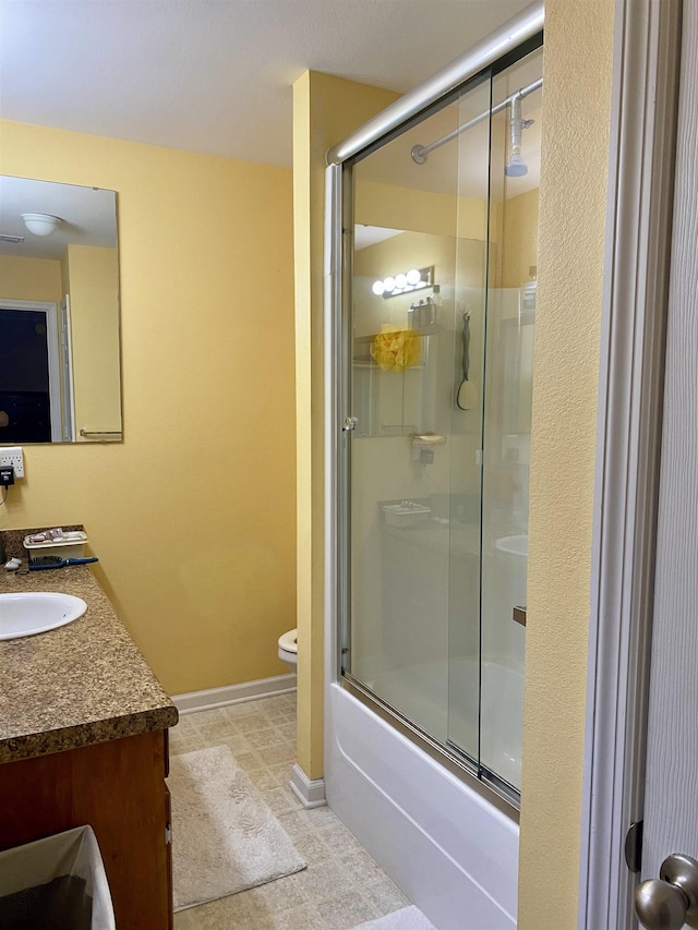 full bathroom featuring toilet, vanity, and shower / bath combination with glass door