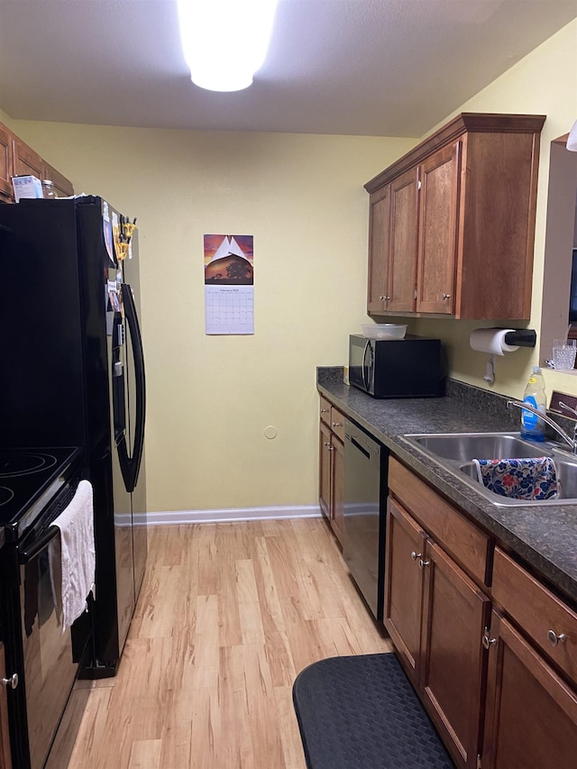 kitchen featuring light hardwood / wood-style flooring, sink, and black appliances