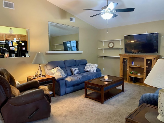 carpeted living room with ceiling fan and lofted ceiling