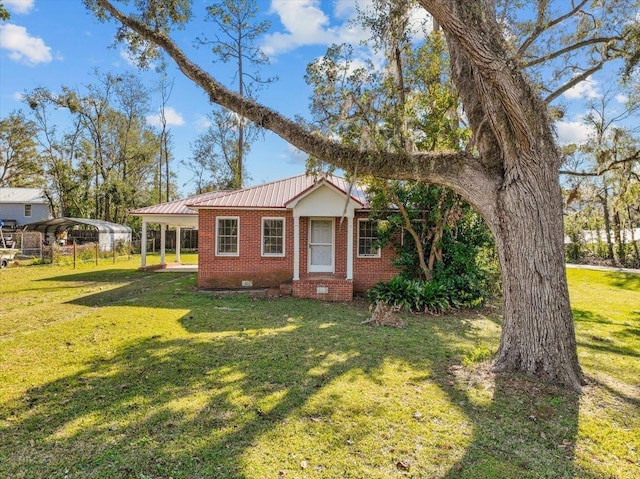 view of front of home with a front yard and a carport