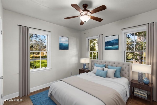 bedroom featuring multiple windows, ceiling fan, and dark wood-type flooring