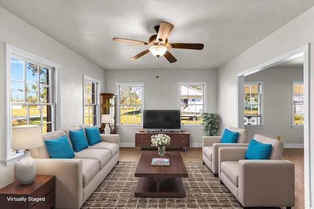 living room with dark hardwood / wood-style flooring, plenty of natural light, and ceiling fan