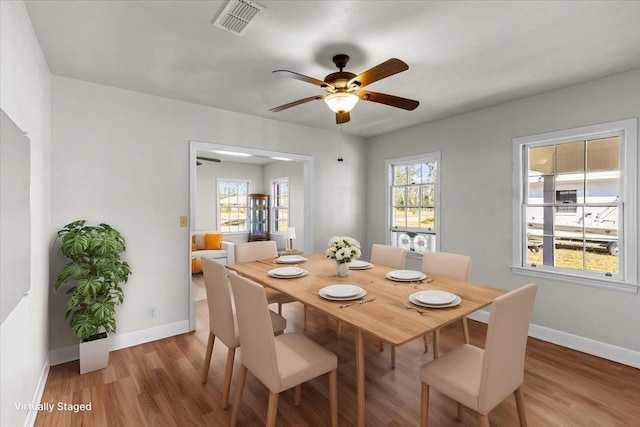 dining space with light hardwood / wood-style flooring and ceiling fan