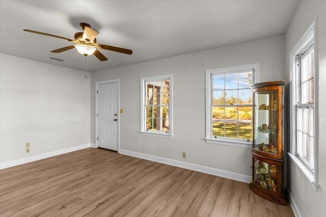 unfurnished room with ceiling fan, plenty of natural light, and light hardwood / wood-style floors