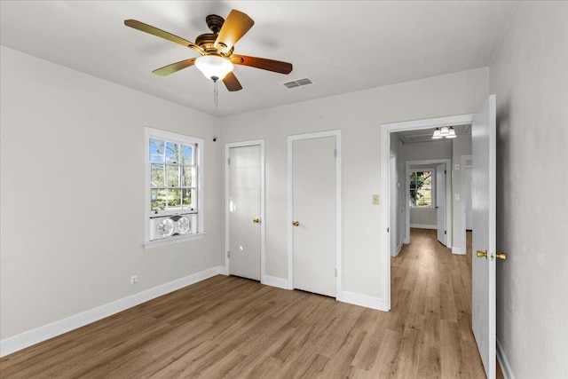 unfurnished bedroom with light hardwood / wood-style flooring, multiple windows, and ceiling fan