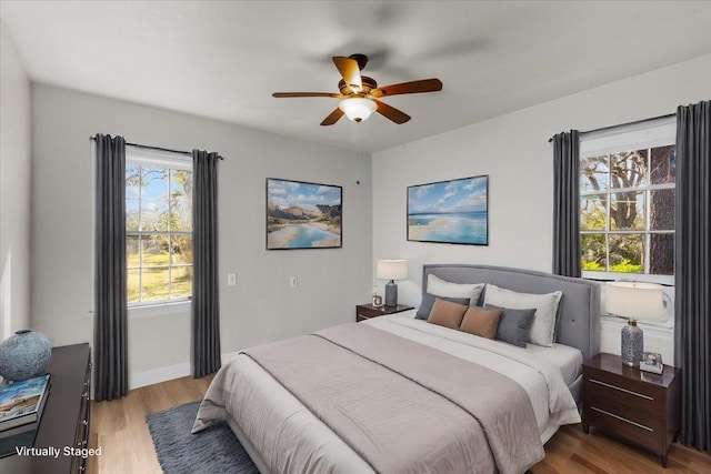 bedroom with light hardwood / wood-style flooring, multiple windows, and ceiling fan