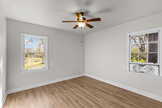 spare room featuring a wealth of natural light, light hardwood / wood-style flooring, and ceiling fan