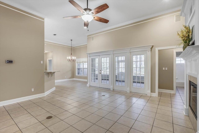 unfurnished living room featuring light tile patterned floors, crown molding, ceiling fan with notable chandelier, and french doors