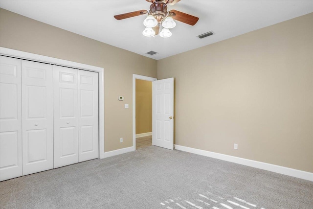 unfurnished bedroom featuring light colored carpet, a closet, and ceiling fan