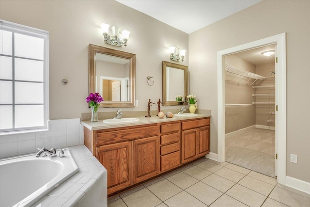 bathroom with vanity, tiled tub, and tile patterned flooring