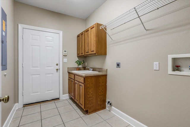 washroom with sink, cabinets, hookup for an electric dryer, and light tile patterned flooring