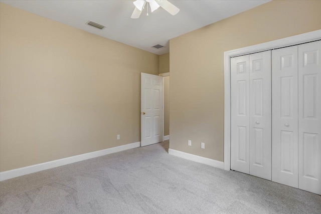 unfurnished bedroom featuring light colored carpet, a closet, and ceiling fan