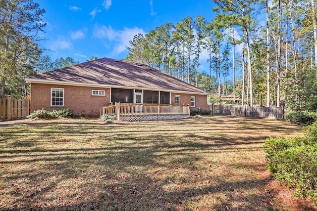 rear view of house with a yard and a deck