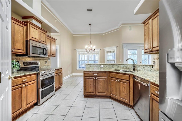 kitchen with sink, light tile patterned floors, appliances with stainless steel finishes, light stone countertops, and kitchen peninsula