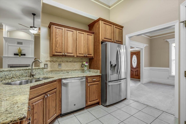 kitchen with sink, appliances with stainless steel finishes, backsplash, ornamental molding, and light carpet