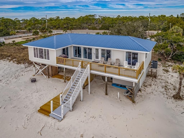 1171 Alligator Dr, Alligator Point, FL 32346 - back of property featuring a deck, metal roof, and view of scattered trees