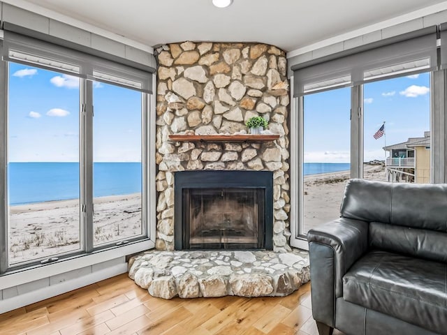 1171 Alligator Dr, Alligator Point, FL 32346 - living area with a water view, wood finished floors, and a fireplace