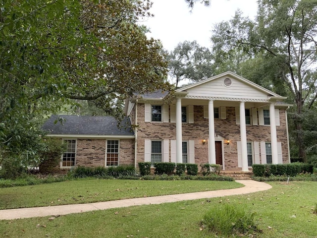 neoclassical / greek revival house featuring a front lawn