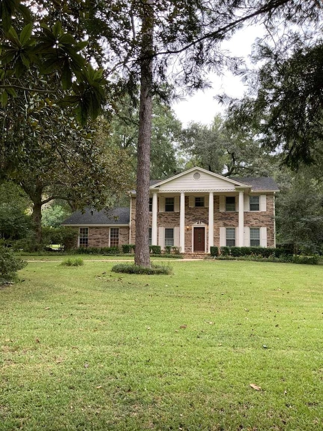 greek revival inspired property with a front yard