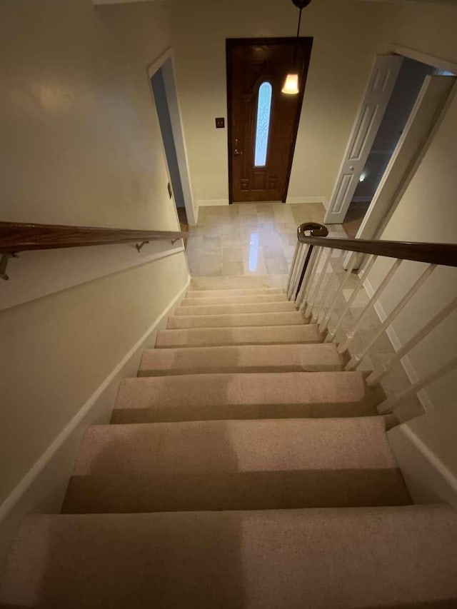 stairway with tile patterned flooring