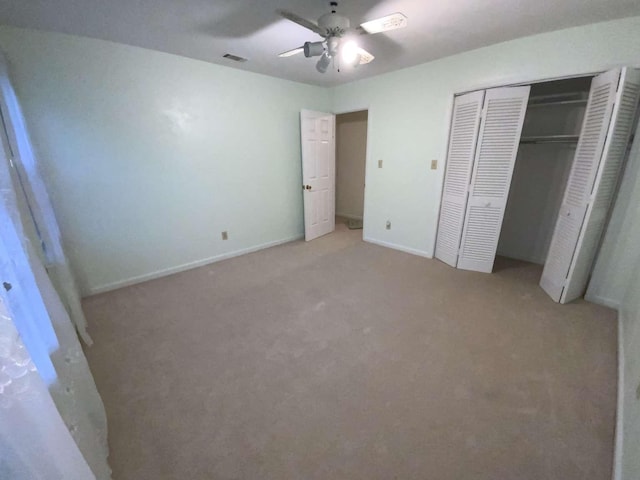 unfurnished bedroom featuring light carpet, ceiling fan, and a closet