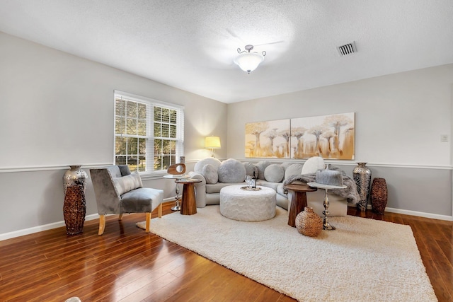 living area featuring a textured ceiling and dark hardwood / wood-style flooring