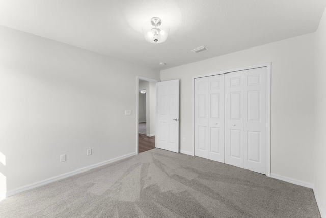 unfurnished bedroom featuring carpet flooring and a closet