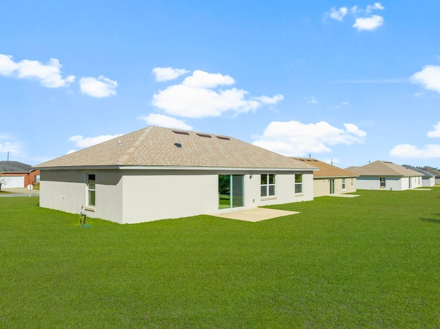 back of house featuring a lawn and a patio area