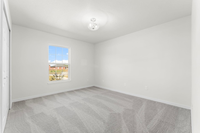 unfurnished room featuring light carpet