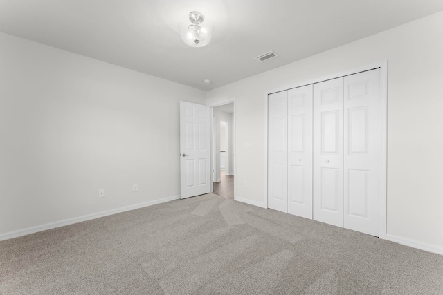 unfurnished bedroom with light carpet and a closet