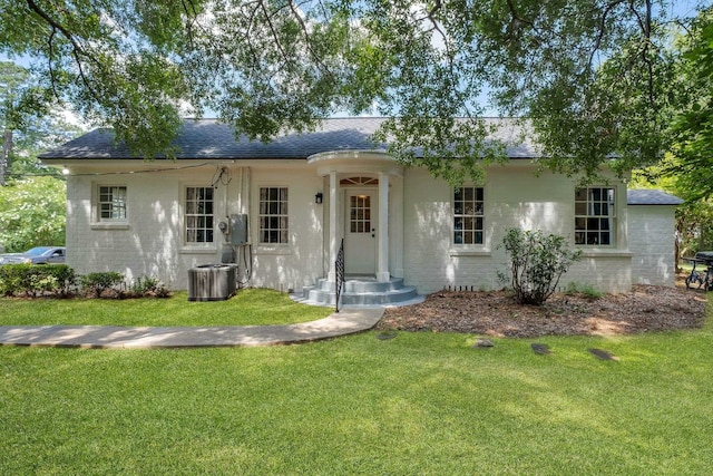 ranch-style house with a front lawn and central air condition unit