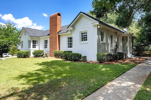 view of front of home with cooling unit and a front yard